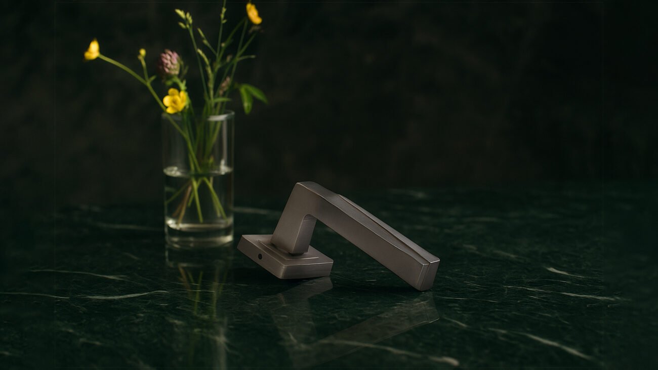Silver KEPA 501 door handle placed on an emerald green marble surface