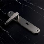 TIDLO 504 silver backplate bathroom door handle placed on a black marble surface