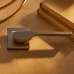 KEPA 502 silver door handle placed on a marble surface beside 2 books