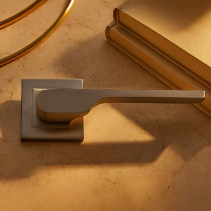 KEPA 502 silver door handle placed on a marble surface beside 2 books