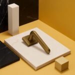 KEPA 509 gold rosette door handle placed on a white rectangular marble surface