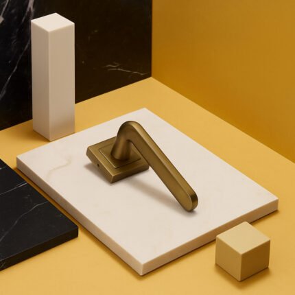 KEPA 509 gold rosette door handle placed on a white rectangular marble surface