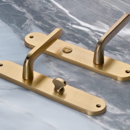 TIDLO 509 gold bathroom handle placed on a marble surface